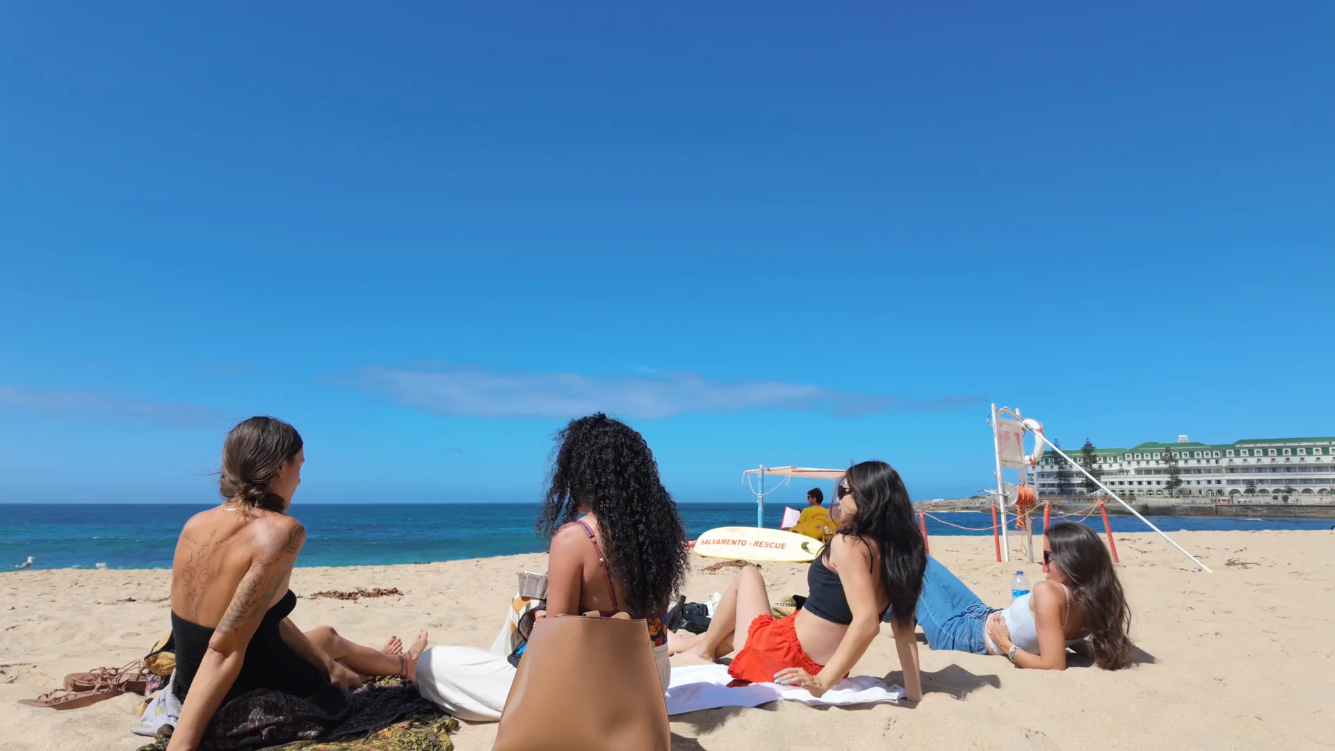 A group of friends chatting together on the beach beside the Atlantic.