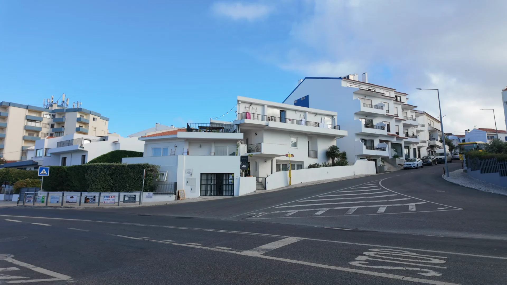 A bus approaches the intersection beside Outsite Boavista in the morning light.