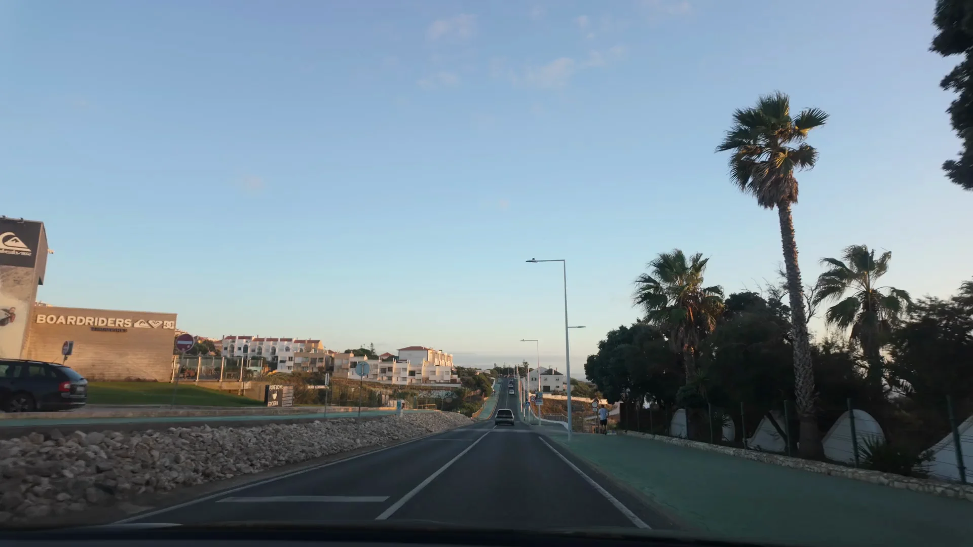 An evening journey along a palm-lined road through Ericeira.